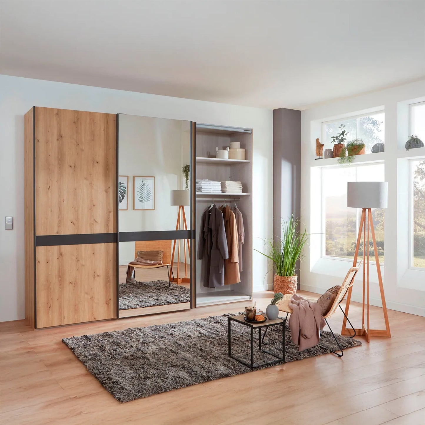 Lifestyle image of Wiemann Regen Bianco Oak 3 Door Sliding Wardrobe With Mirror, shows interior of one compartment