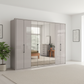 Wiemann Saka 300cm Bi-Fold Wardrobe With 4 Glass Doors & 4 Mirror Doors in Pebble Grey Glass styled in a modern bedroom