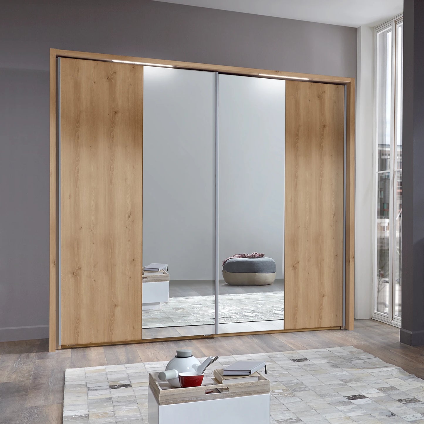Modern sliding wardrobe with wooden doors and mirror panels in a room.