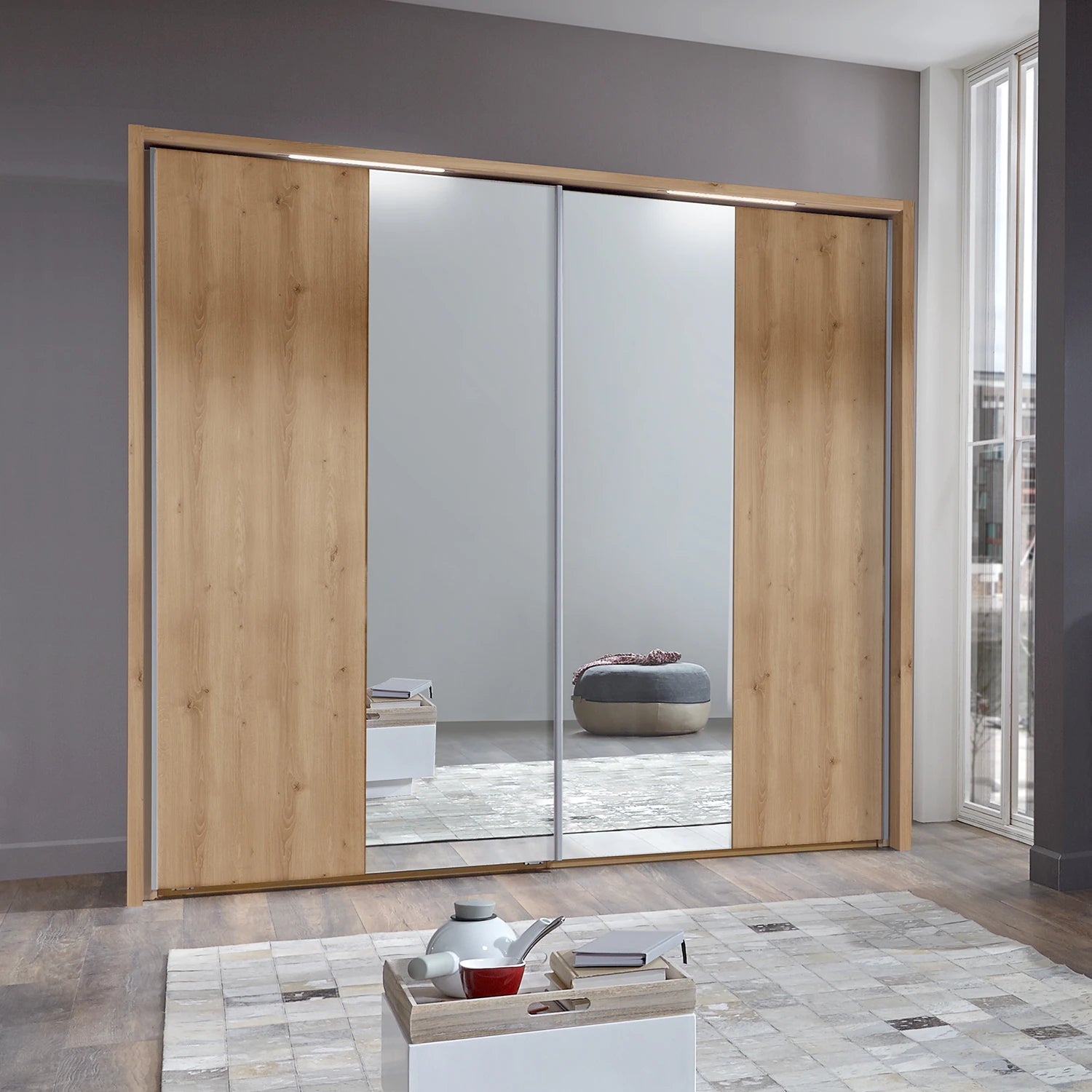 Modern sliding wardrobe with wooden doors and mirror panels in a room.