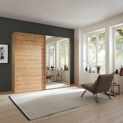 The Korfu Bianco Oak Sliding Wardrobe features mirrored 3-panel doors, smooth-glide rails, adjustable shelves and space-saving style. Choose 200–300cm sizes and mirror side.

