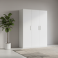 White wardrobe in a minimalistic room with a plant and abstract art on the wall.