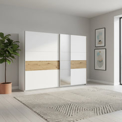 Modern sliding wardrobe with white and wood design in a room with a plant and abstract art.