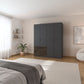 Modern bedroom with a large dark gray wardrobe with drawers in dark wood