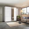 Modern bedroom with a large white wardrobe, beige sofa, and decorative items.