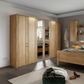 Wooden wardrobe with mirrored doors in a bedroom setting