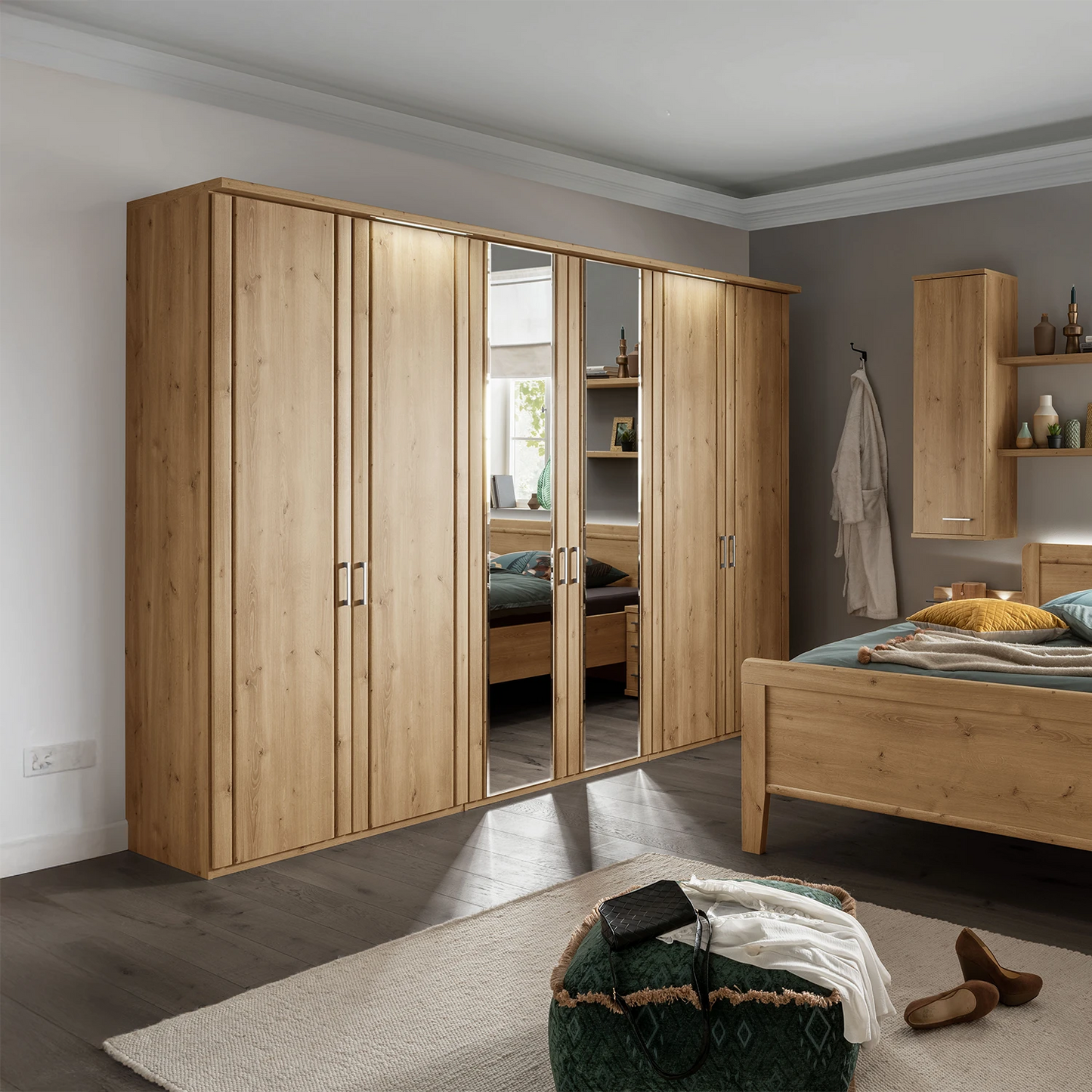 Wooden wardrobe with mirrored doors in a bedroom setting