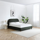 Lifestyle image of the Mallow Olive Boucle Fabric Upholstered Bed with Walnut Legs