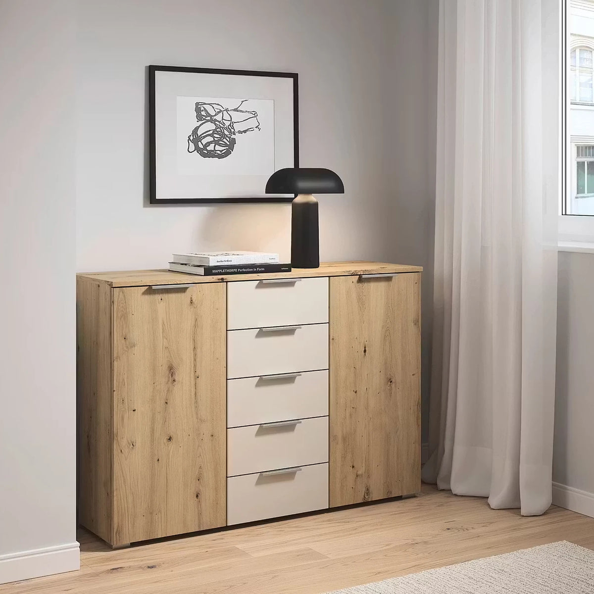 Rauch Monza 2 Doors & 5 Drawers Chest - 120cm in Artisan Oak & Champagne styled in a modern bedroom