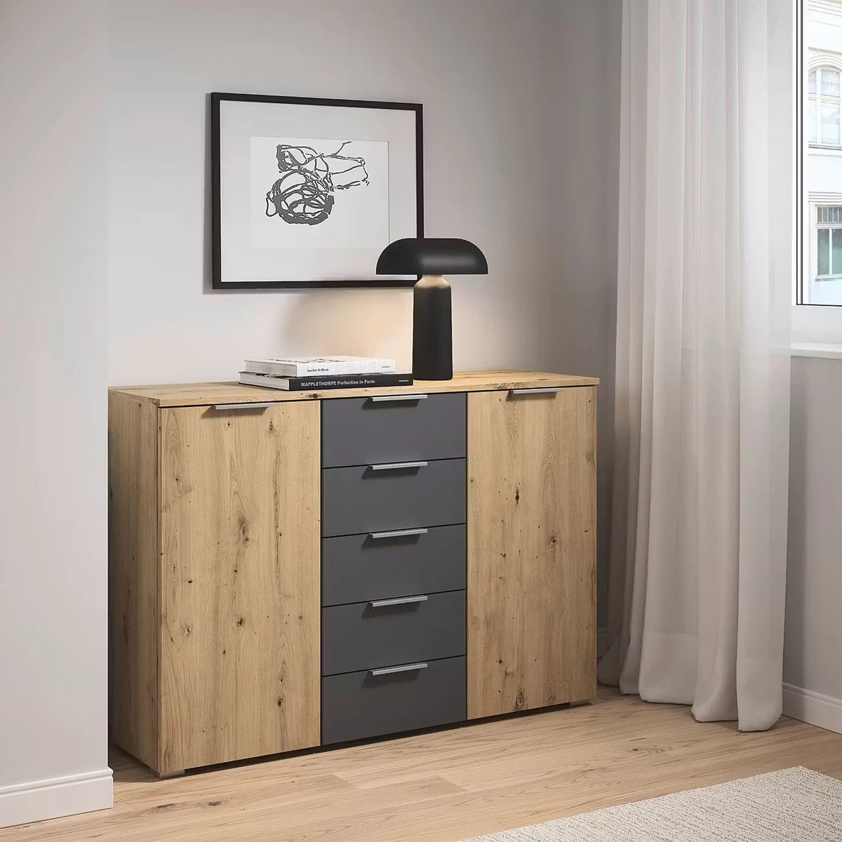 Rauch Monza 2 Doors & 5 Drawers Chest - 120cm in Artisan Oak & Metallic Grey styled in a modern bedroom