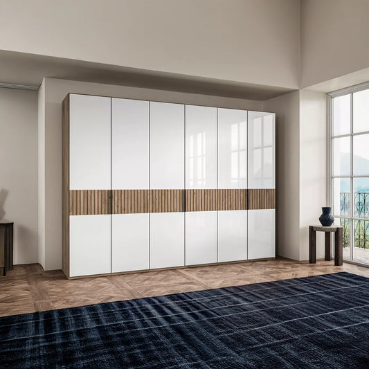 Modern Newlin wardrobe with white doors and wooden accents in a room with large windows.