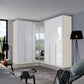 A modern corner wardrobe set with glossy white doors and mirrored Doors in the Middle, shown installed in a contemporary bedroom interior.