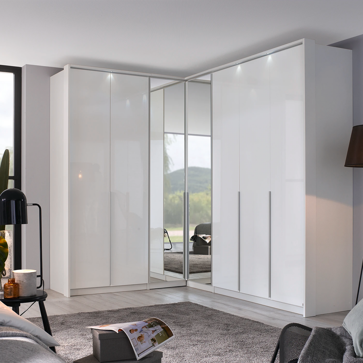 A modern Rauch white high-gloss Hinged door corner wardrobe system with Middle mirror doors and LED light Passepartout Frame