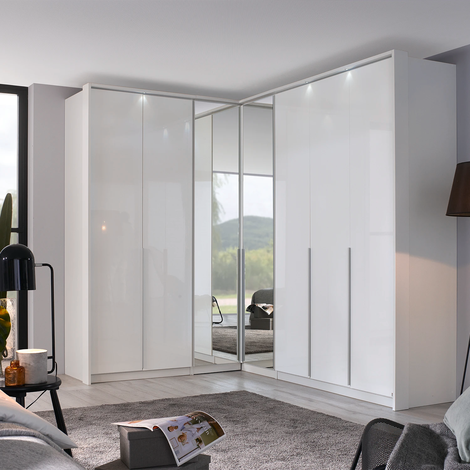 A modern Rauch white high-gloss Hinged door corner wardrobe system with Middle mirror doors and LED light Passepartout Frame