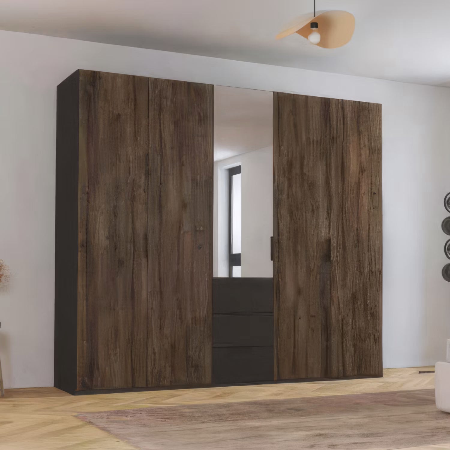 A large 5 Door wardrobe in dark brown Atlantic Oak wood grain doors and a central mirror Door, and 3 drawers set in a modern room with light wood flooring and white walls.