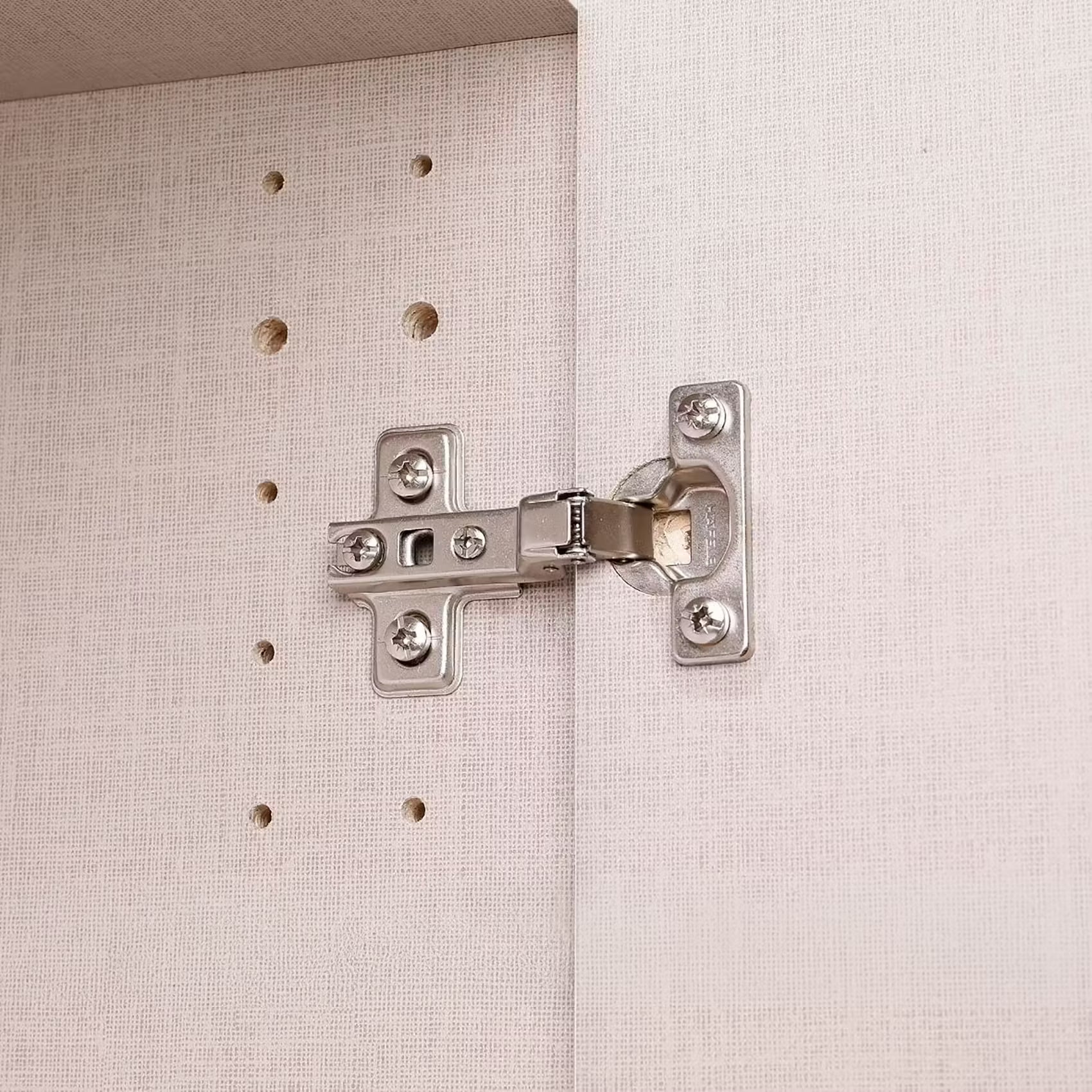 Close-up of a silver metal wardrobe hinge mounted on a Atlantic Oak 3 Door wardrobe