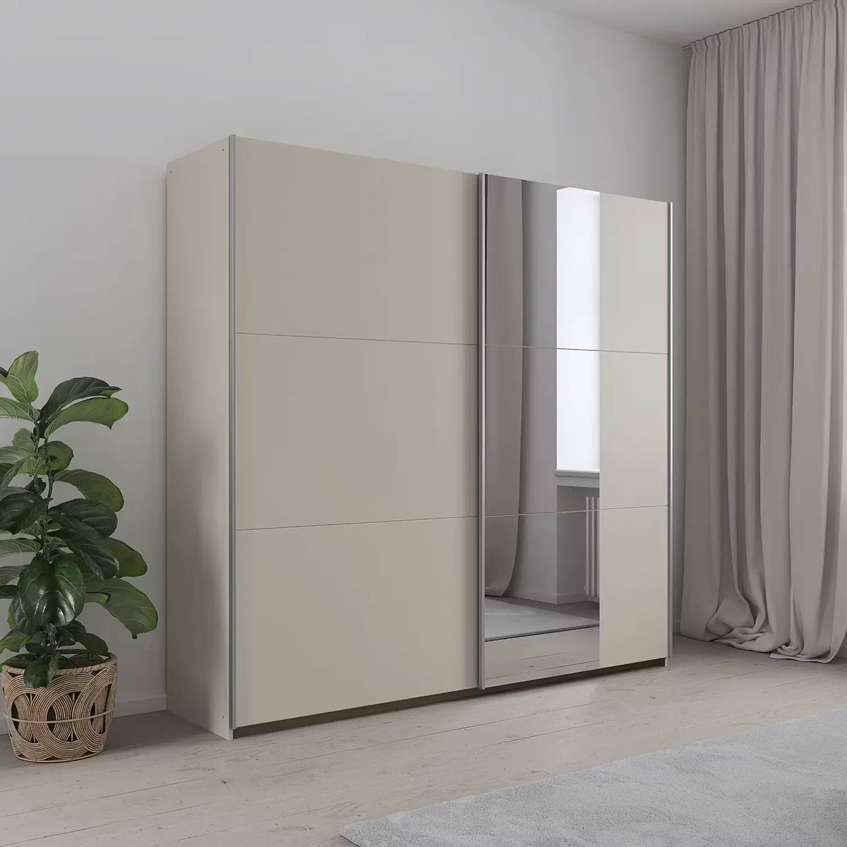 A modern two-door wardrobe with two solid beige doors With mirror on one door, shown in a minimalist room setting with a potted plant and curtains.