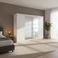 Modern bedroom with a large white wardrobe, bed, and decorative elements.