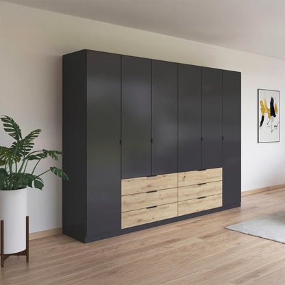 Large black wardrobe with wooden drawers in a room with a plant and artwork on the wall.