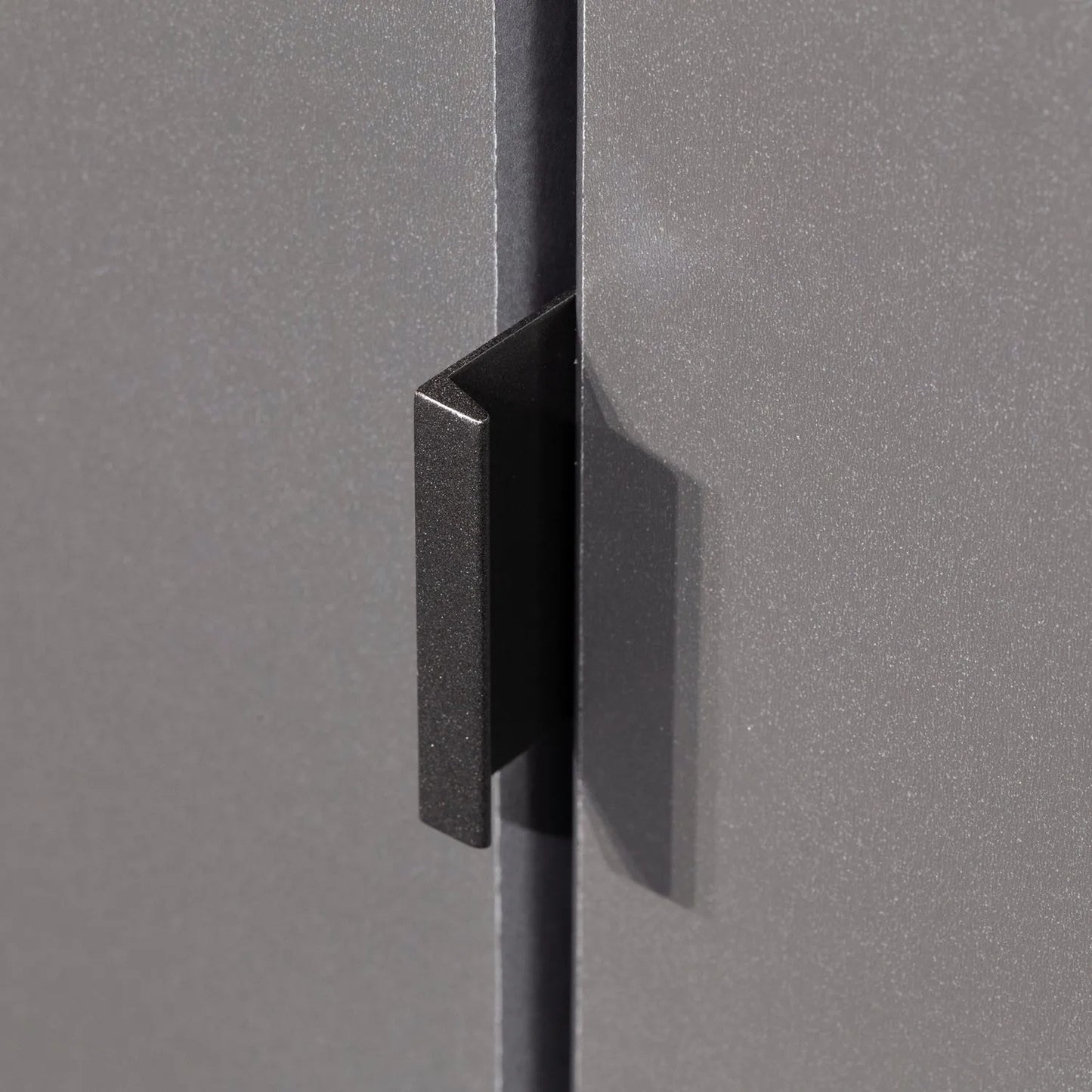 Close-up of a black cabinet handle on a gray cabinet door