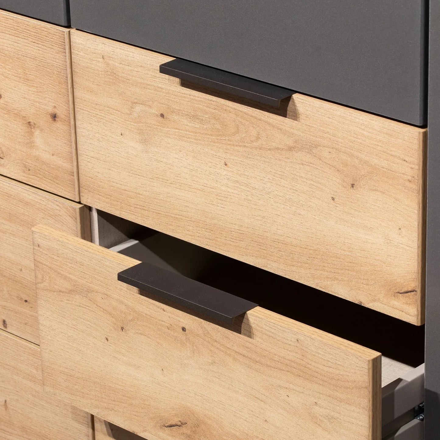 Wooden drawer with black handle on a Rauch Davo 4 door wardrobe with mirror doors and Artisan Oak drawers