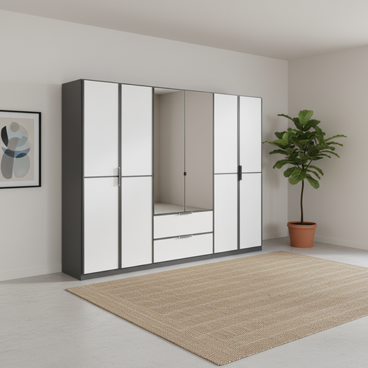A modern Large Rauch Essensa wardrobe with white doors and dark gray trim, featuring mirrored panels and a central drawer section, shown in a minimalist room with a beige rug and a potted plant.