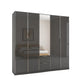 A modern Rauch Essensa Prme five -door wardrobe with Basalt Glass doors and one central mirrored door with two drawers underneath, shown on a plain white background.