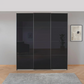 Black sliding wardrobe doors in a room with a gray wall and a framed picture.