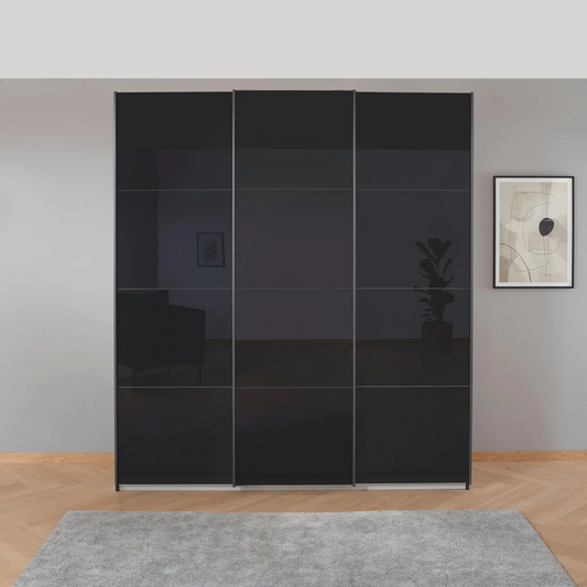 Black sliding wardrobe doors in a room with a gray wall and a framed picture.