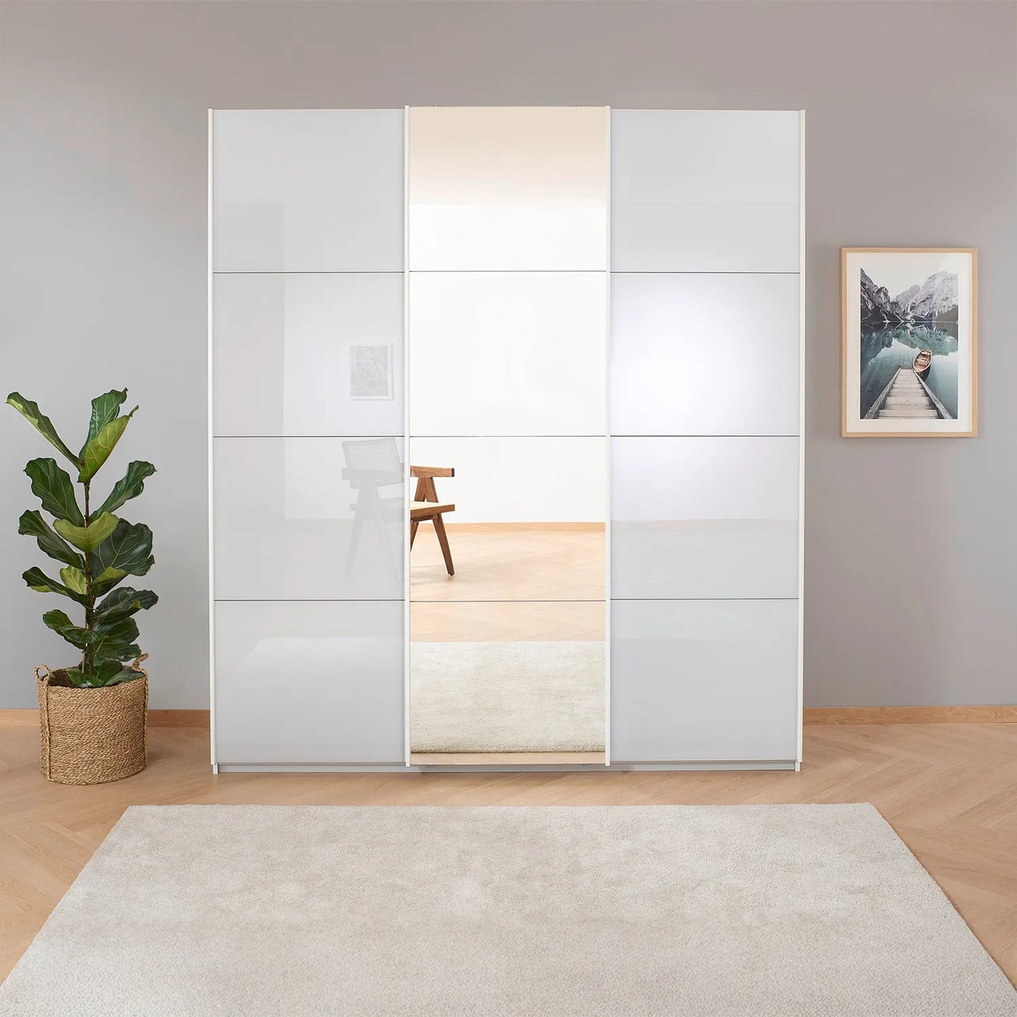 Rauch Forms White Glass 3 Door Sliding Wardrobe with Mirror - Styled in a Bedroom