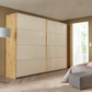 Rauch Freja Glass Door Sliding Wardrobe in Champagne front with Oak Carcase styled in a modern bedroom