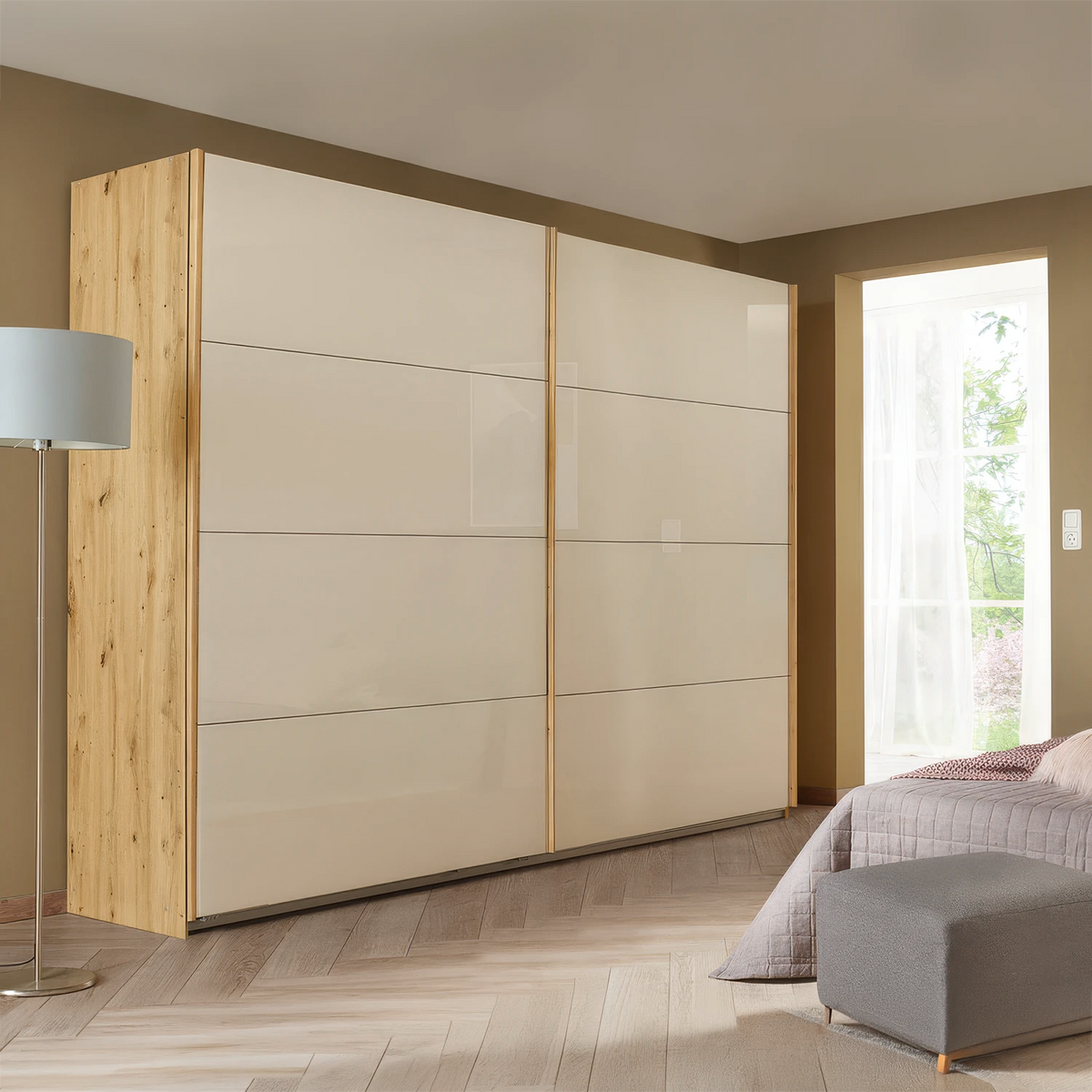 Rauch Freja Glass Door Sliding Wardrobe in Champagne front with Oak Carcase styled in a modern bedroom
