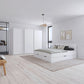 A modern bedroom featuring a white platform bed with built-in storage drawers, a matching white Rauch Impulse three-door wardrobe