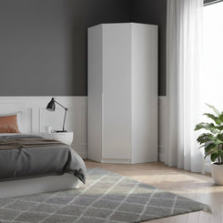 A tall white corner wardrobe in a modern bedroom setting with a gray wall, white wainscoting, a bed, a side table with a black lamp, sheer white curtains, and a potted green plant.