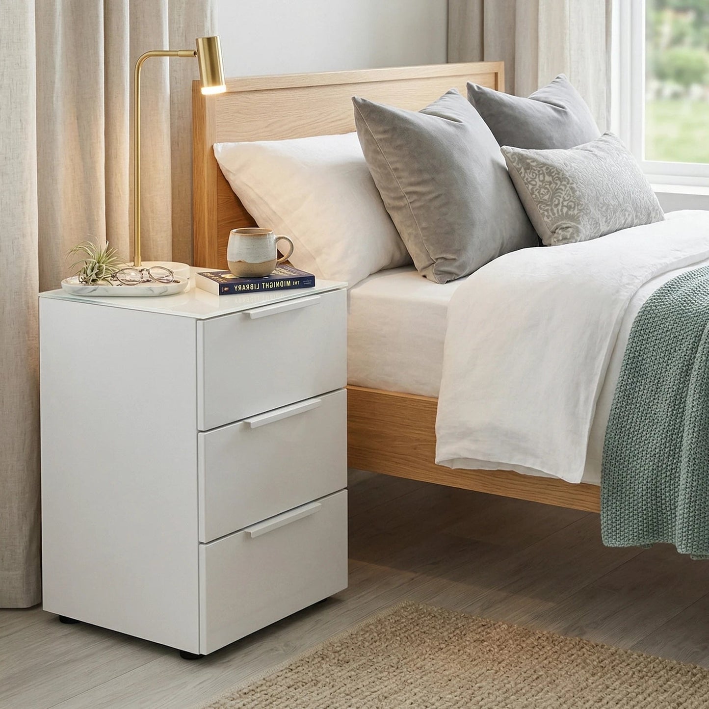 Rauch Heaven 3 Drawer Bedside Cabinet with Glass Top and Front - Styled in a Bedroom