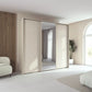 Rauch Tara 3 Door Sliding Wardrobe in Champagne with central mirror door with passepartout frame styled in a modern bedroom