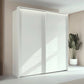 Rauch Taro 2 Door Sliding Wardrobe in Alpine White finish styled in a modern room 
