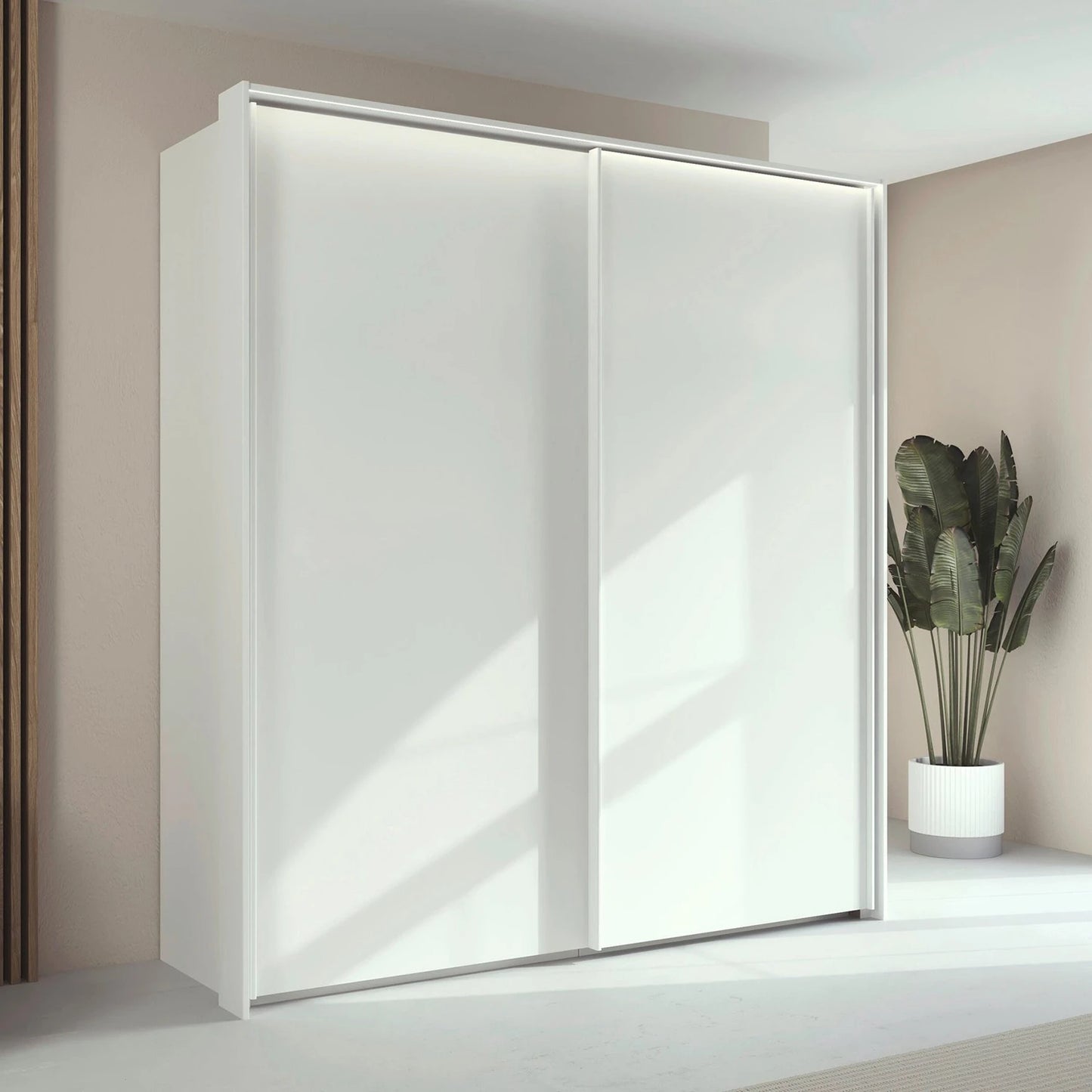 Rauch Taro 2 Door Sliding Wardrobe in Alpine White finish styled in a modern room 