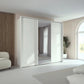 Rauch Tara 3 Door Sliding Wardrobe in Alpine White with central mirror door with passepartout frame styled in a modern bedroom