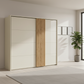 A modern sliding wardrobe with cream-colored doors and a vertical wooden slat panel in the center, shown in a bright, minimalist room with a potted plant and light wood flooring.
