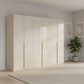 Rauch Heaven 300cm 6 Door Hinged Wardrobe with Glass Doors in Champagne styled in a modern bedroom