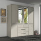 A tall, modern Wiemann Cairns wardrobe or closet with four doors and two mirrored doors, featuring silver horizontal handles and a lower section with two drawers, shown in a minimalist room setting.