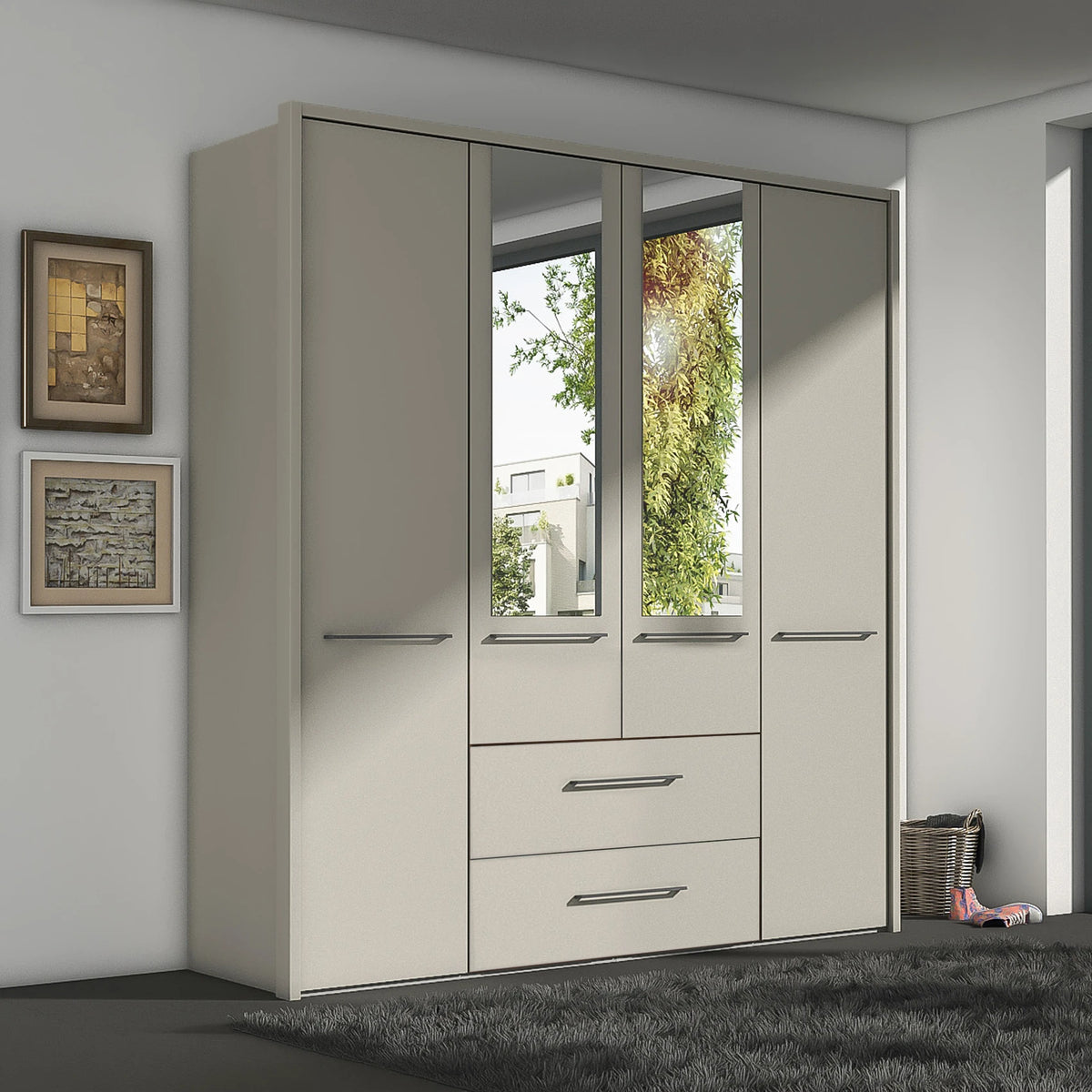 A tall, modern Wiemann Cairns wardrobe or closet with four doors and two mirrored doors, featuring silver horizontal handles and a lower section with two drawers, shown in a minimalist room setting.