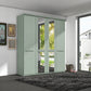 A tall four-door Wiemann Cairns wardrobe in a pale sage green finish, featuring two doors with mirrored glass panels and two solid doors with horizontal handles, shown in a modern room setting.