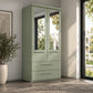 A sage green Wiemann Cairns two-drawer wardrobe with two mirrored upper doors and silver handles, shown in a modern room setting with a window, potted plant, and rug.