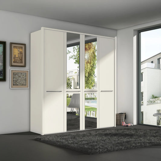 A modern white Wiemann Cairns wardrobe with two mirrored doors and two solid doors, set in a contemporary room with a dark gray rug and framed wall art.