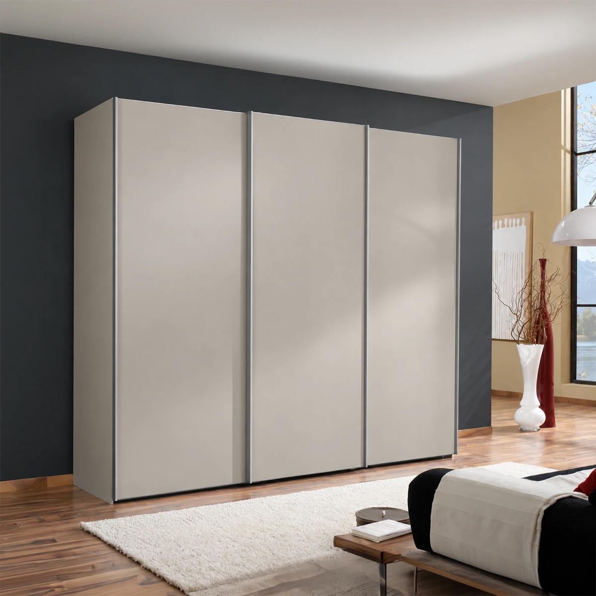 A modern Low height  three-door Wiemann Darwin wardrobe with matte Pebble Grey doors, Aluminium Door handle Bars