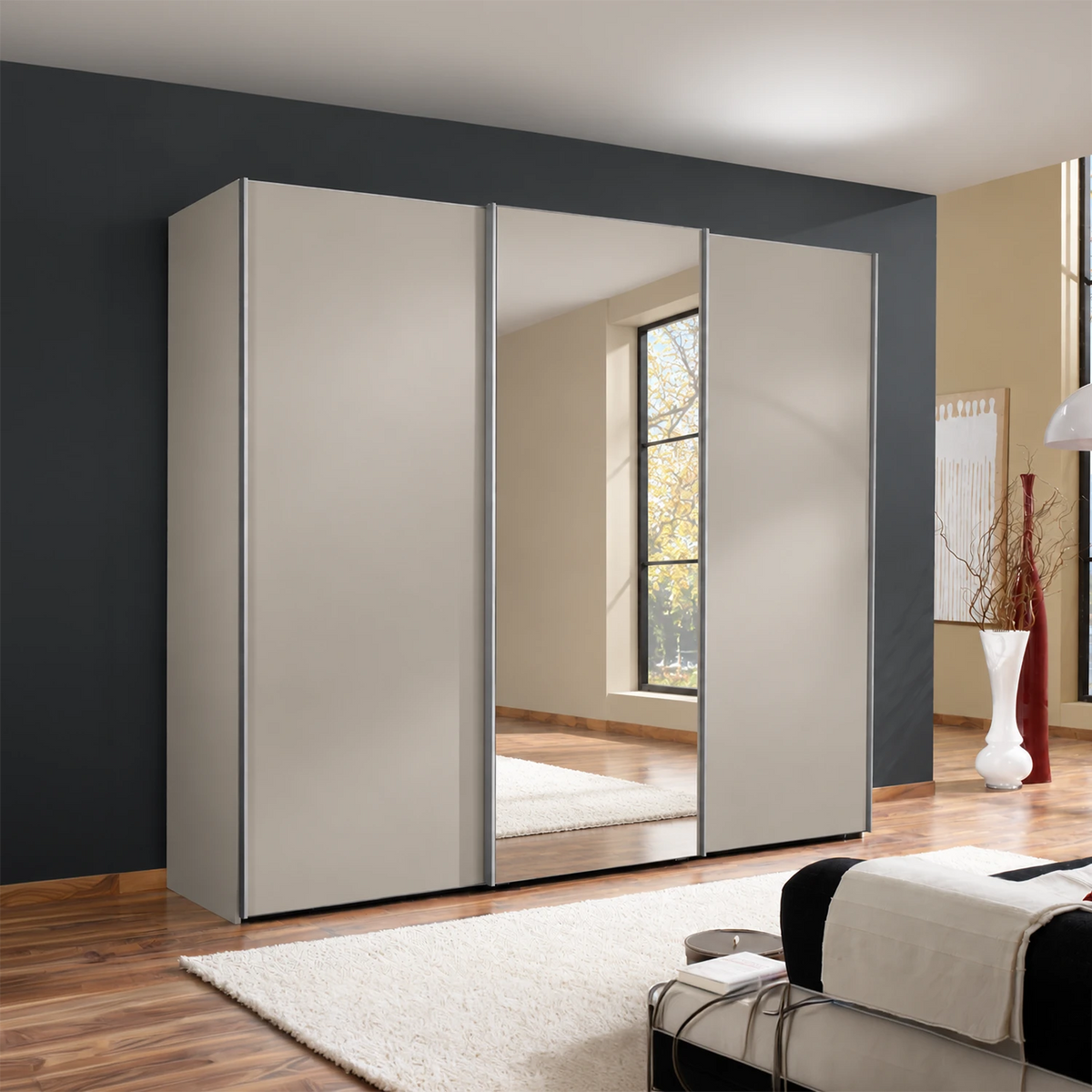Wiemann Darwin 3 Door Mirror Sliding Wardrobe With Low Height  in Pebble Grey styled in a modern bedroom