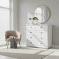 White dresser with round mirror in a bright room
