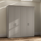 A tall four-door Wiemann trurp wardrobe or closet in a pebble gray finish with a natural wood top, shown in a room with beige walls and wood flooring.